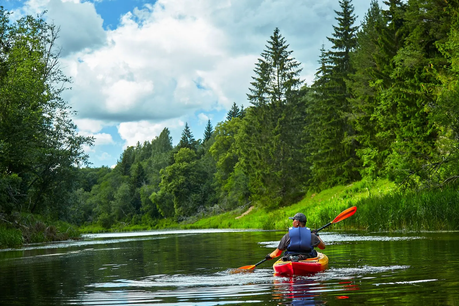 Kayaking a green river near the Blue Springs Recreational Area