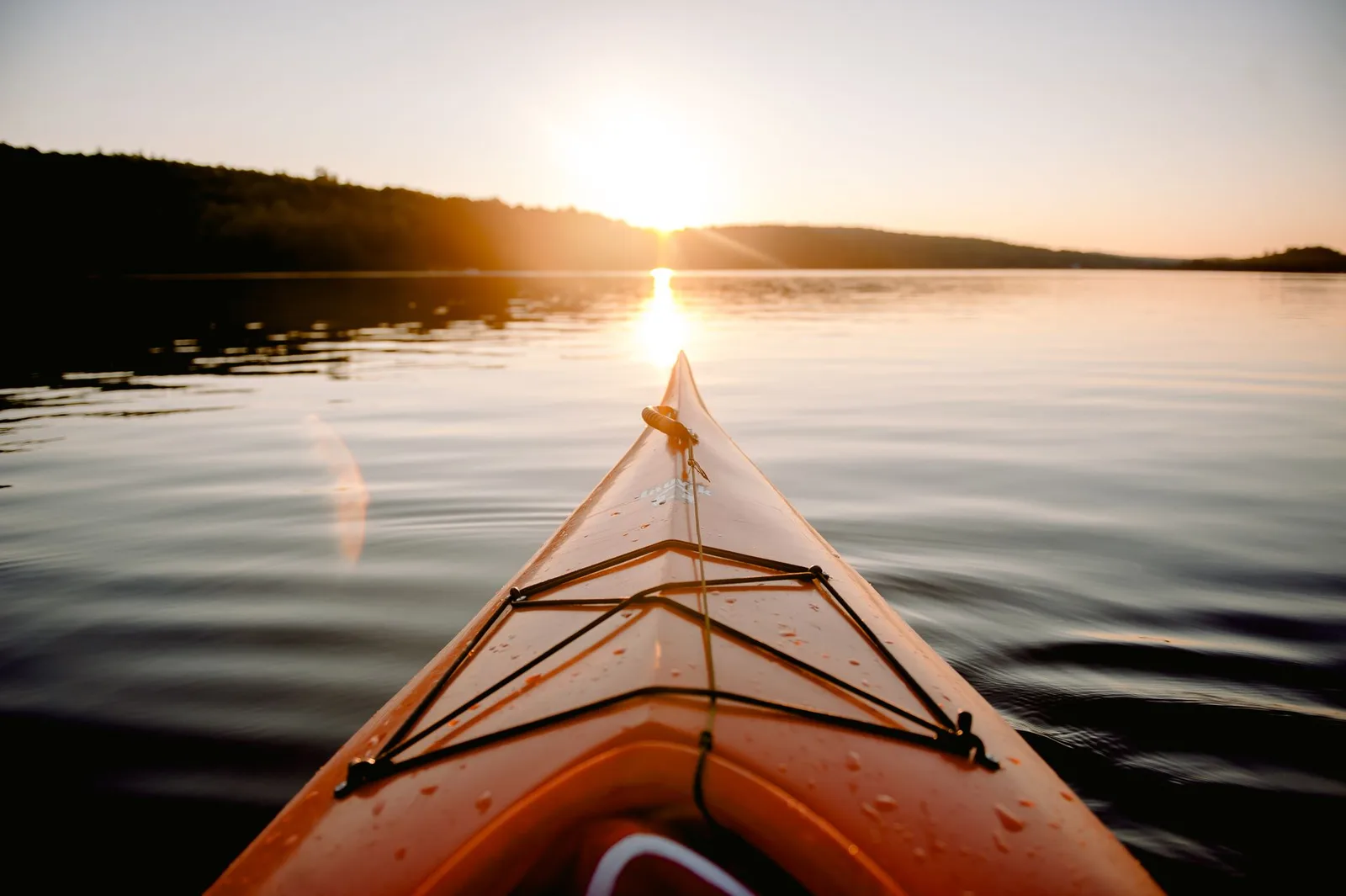 Nature property in Florida — the bow of a kayak crossing calm water at sunset